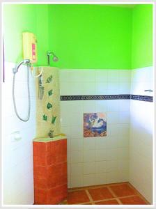 eine Dusche in einem Badezimmer mit grünen und weißen Fliesen in der Unterkunft The Emerald Krabi Beach Resort in Klong Muang Beach + 62 Fotos