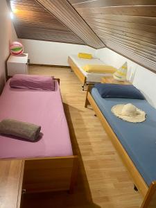 three beds sitting in a room with wooden floors at Uno Due Tre Stella in Chioggia