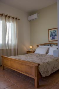 sypialnia z dużym łóżkiem i oknem w obiekcie Sirines Apartments w mieście Palekastron