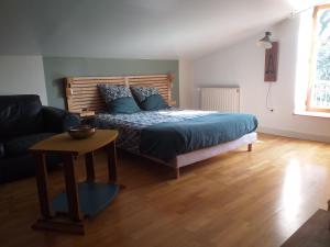 a bedroom with a bed and a table and a couch at clos st Joseph in Oullins