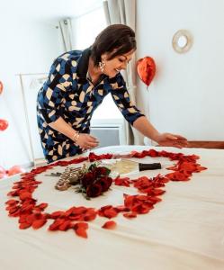 a woman is arranging roses on a table at le refuge des cépages - essoyes in Essoyes