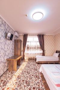a hotel room with two beds and a table at Major Guest House in Fergana