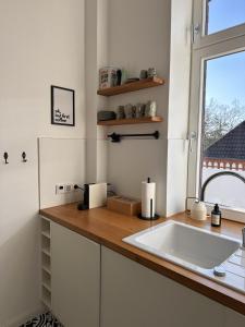 a kitchen with a white sink and a window at Stilvolle Altbauwohnung mit Charme in Wesel +25 photos