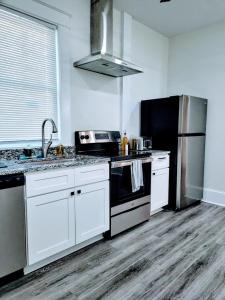 a kitchen with white cabinets and a black refrigerator at Walk To Duke Campus! 1 Bedroom In Trinity Park! in Durham