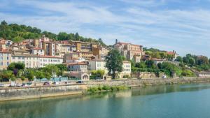 a town on a hill next to a river at La Nichée appartement 2 chambres in Trévoux