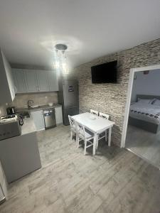 a kitchen with a white table and a room with a bed at Casa Berbec 3 Studio in Dealul Viei