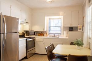a kitchen with a stainless steel refrigerator and a table at Bungalow 7- Downtown, cozy, comfortable in Wilmington