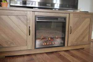 a fireplace in a wooden cabinet with a fire in it at Bungalow 7- Downtown, cozy, comfortable in Wilmington +13 photos