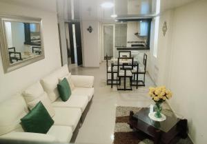 a living room with a white couch and a table at Hogar del Bosque in Nobsa