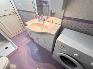 een badkamer met wastafel en wasmachine bij Dimora Del Corallo in Gallipoli +17 foto's
