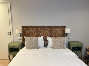 a bedroom with a bed with two green end tables at Irin Hotel in Antibes