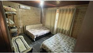 a small room with two beds in a brick wall at Casa de campo in Itapema +11 photos