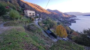 a house on the side of a hill next to the water at Rustico verginate 3 in Bellano