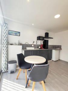 een keuken met een tafel en stoelen in een kamer bij studio avec terrasse et parking privatif in Courthézon