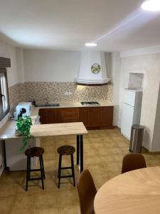 a kitchen with a table and two chairs and a refrigerator at Casa Teresa in Alcalá del Júcar +10 photos
