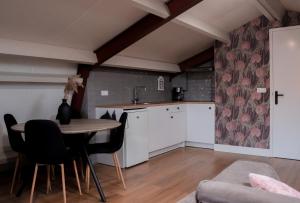 a kitchen with a table and chairs in a room at B&B De Kalverschuur in Schoonrewoerd