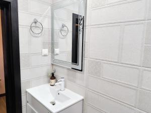 a white bathroom with a sink and a mirror at St Sava Legendary House in Veliko Tŭrnovo +100 photos