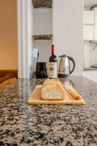 a bottle of wine and a loaf of bread on a cutting board at Cabanal Beach House - 10 min to ocean , FastWifi , SmartTV, AC in Valencia +33 photos