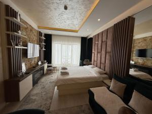 Un dormitorio con una cama, un escritorio y un sofá. en Apartmani Fashion -Milmari Resort, en Kopaonik