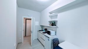 een witte keuken met een magnetron en een fornuis bij GS Apartments Tropea in Tropea