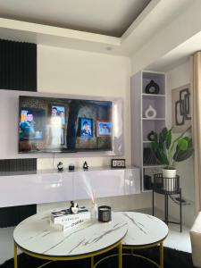 a living room with two tables and a tv on the wall at LUCKY 7 Suites in Manila