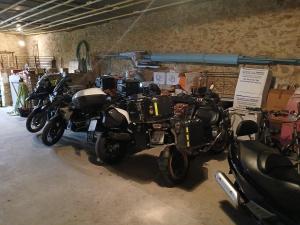 a group of motorcycles parked in a garage at Chambres d'hôtes Sous L'Olivier in Trausse