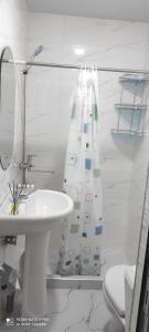 a bathroom with a sink and a shower curtain at Farida Bonu Sam in Samarkand