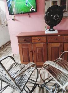 a room with two chairs and a television and a table at Casa mobiliada com 3 quartos para a COP 30 in Belém