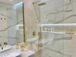 a white bathroom with a shower and a sink at Apartament DeLuxe Zamość Prywatny parking podziemny in Zamość +29 photos