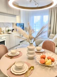 a dining room table with a vase and plates of food at Apartament DeLuxe Zamość Prywatny parking podziemny in Zamość