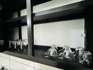 a row of glasses sitting on a shelf at Sunrise Boutique Villa in Kozhikode
