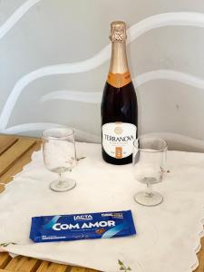 a bottle of beer and two glasses on a table at Chalé caiçara aconchegante in Paraty +38 photos