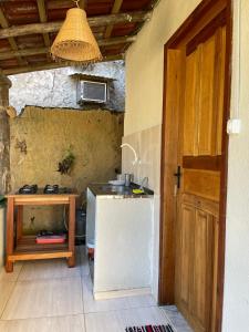 a small kitchen with a sink and a table at Chalé caiçara aconchegante in Paraty