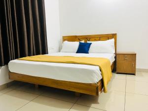 a bedroom with a large bed with a yellow blanket at Sunrise Boutique Villa in Kozhikode