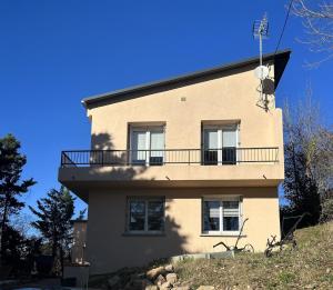 a building with a balcony on top of a hill at Maison avec piscine in Gaillac