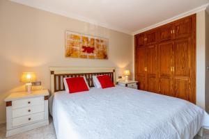 a bedroom with a bed with two red pillows at Apartment Sol 2 in Port de Soller