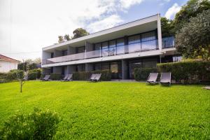 a building with chairs on a lawn in front of it at Casa do Manuel in Santana