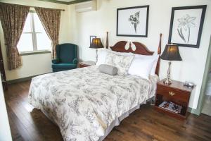 a bedroom with a large bed and a blue chair at Lanes Privateer Inn in Liverpool