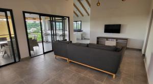 a living room with a couch and a television at RésidenceSuisse Roof-Top in Nosy Be