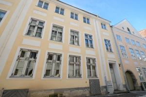 a yellow building with windows on a street at Tallinn City Apartments 2 bedroom & 2 bathroom luxury property with balcony in Old Town in Tallinn