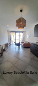 a living room with a couch and a chandelier at Luxury Beach Villa, Praia de Chaves, Boa Vista in Boa Ventura