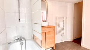 a bathroom with a tub and a sink and a mirror at Historical center in apartment XVIII th century in Bordeaux +13 photos