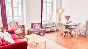 a living room with a red couch and a table at Historical center in apartment XVIII th century in Bordeaux