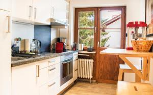 a kitchen with white cabinets and a window at FEWO Immenstadt, Apt. Susanne in Immenstadt im Allgäu