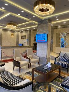 a lobby with chairs and a table and a tv at امواج الشرق للشقق المخدومه in Khamis Mushayt