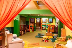 a living room with orange curtains and a play room at Dallia Loft Space in Goumenissa