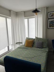 a bedroom with a bed with pillows and windows at Mieszkanie z basenem i siłownią Bronowicka in Szczecin