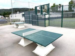 a tennis court with two tables and a tennis racket at Mobilhome 3 chambres Clim 6 Personnes in Vic-la-Gardiole