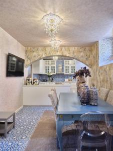 comedor con mesa azul y cocina en Luxurious House Vasiliki with great view, en Hydra