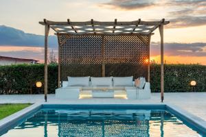 a white couch sitting under a pergola next to a pool at Magnolia Mansion in Kalamata +96 photos